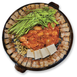무쇠미나리삼겹 — 삼겹살과 김치 위에 생미나리를 올린 모습 (본사 메뉴 사진)