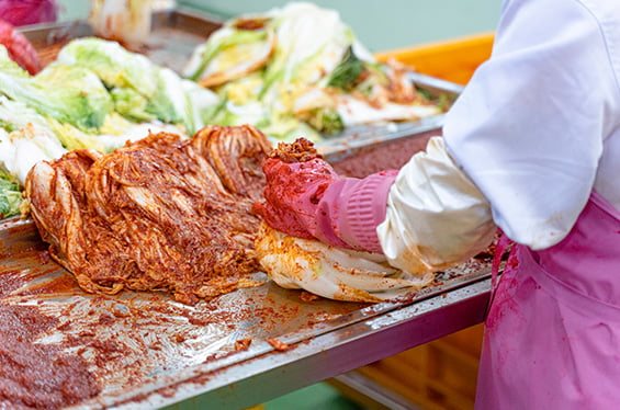부산 기장의 본사 자체 공장에서 절인 배추에 김치 양념을 버무리는 모습